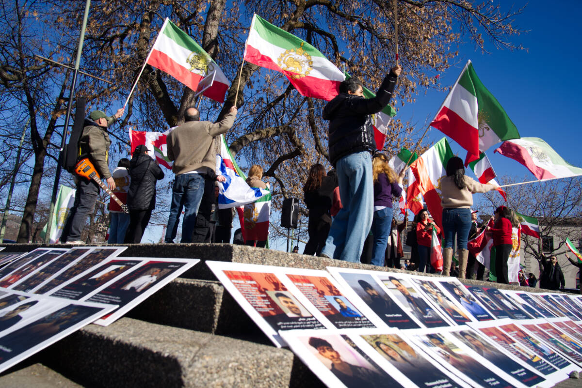 Photos of those killed in protests in Iran laid out on steps in downtown Kelowna&rsquo;s Kerry Park on March 1. (Ty Lim/Kelowna Capital News)