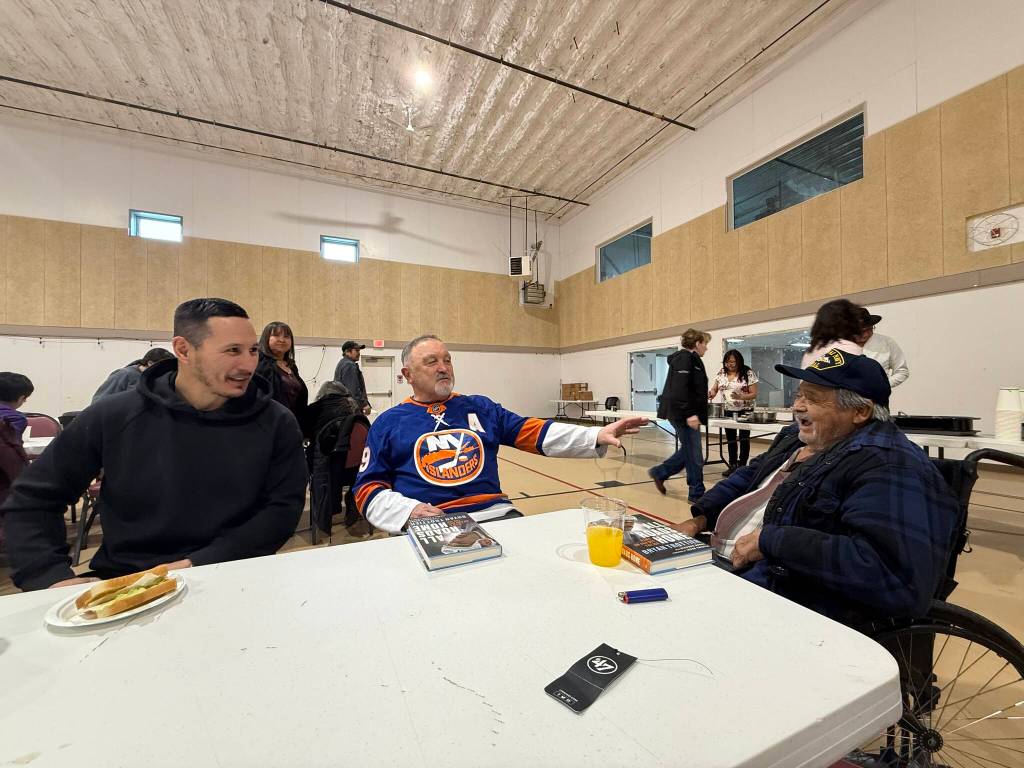 Former NHL players Jordin Tootoo and Bryan Trottier meet with a Tahltan Elder during community events at the Telegraph Creek recreation centre ahead of the Tahltan Winter Classic. Supplied photo